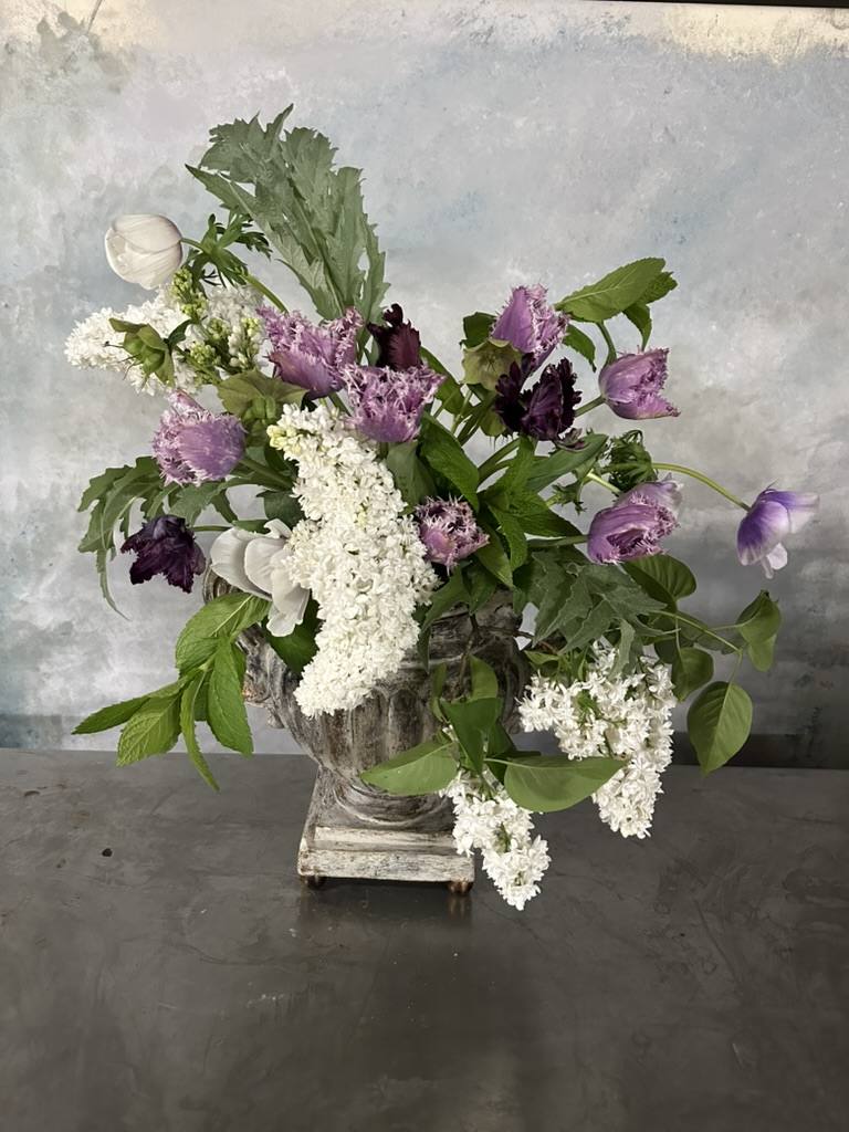 Lilac and white floral arrangement in urn