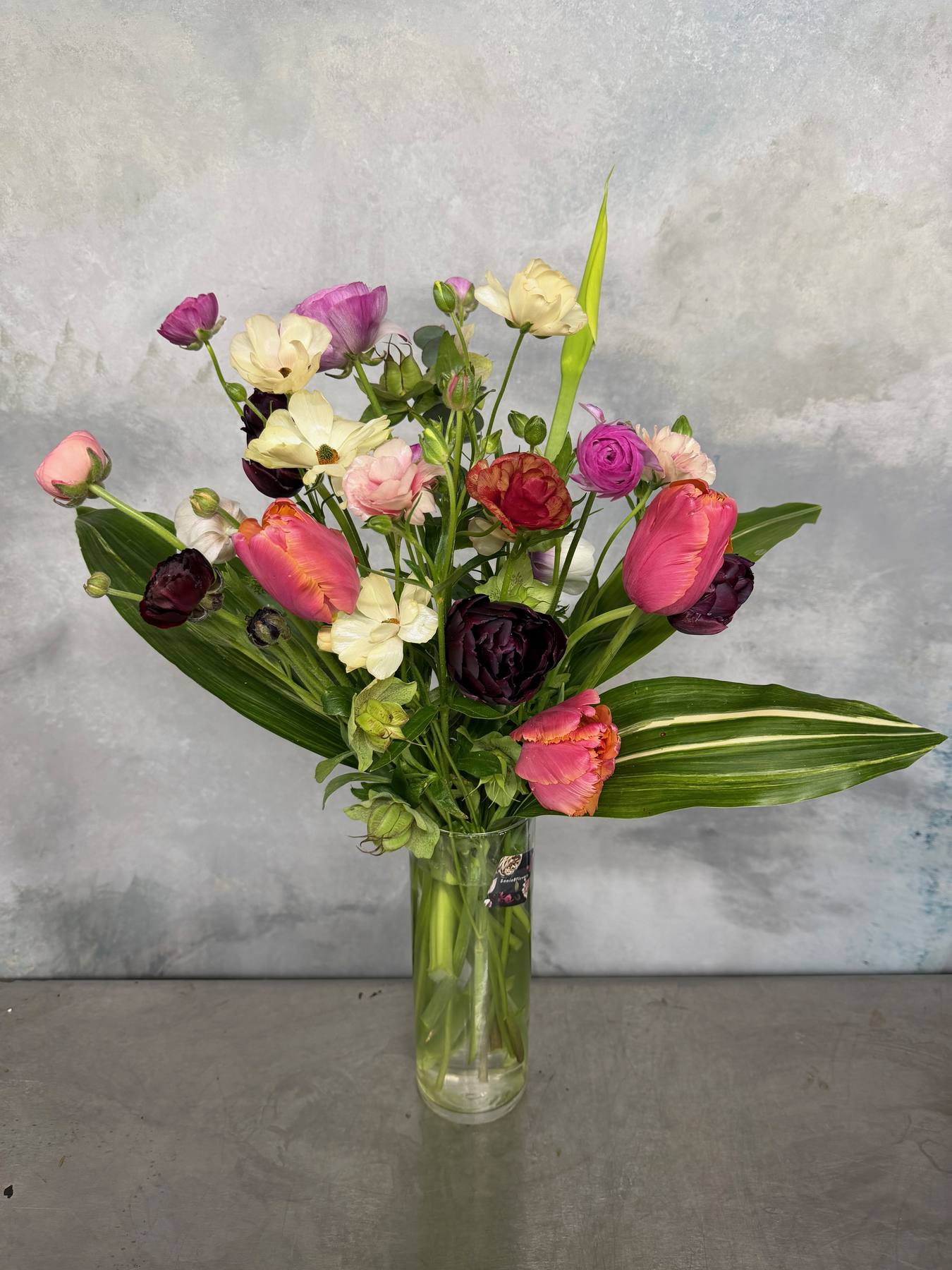 Seasonal mixed flower arrangement in glass vase