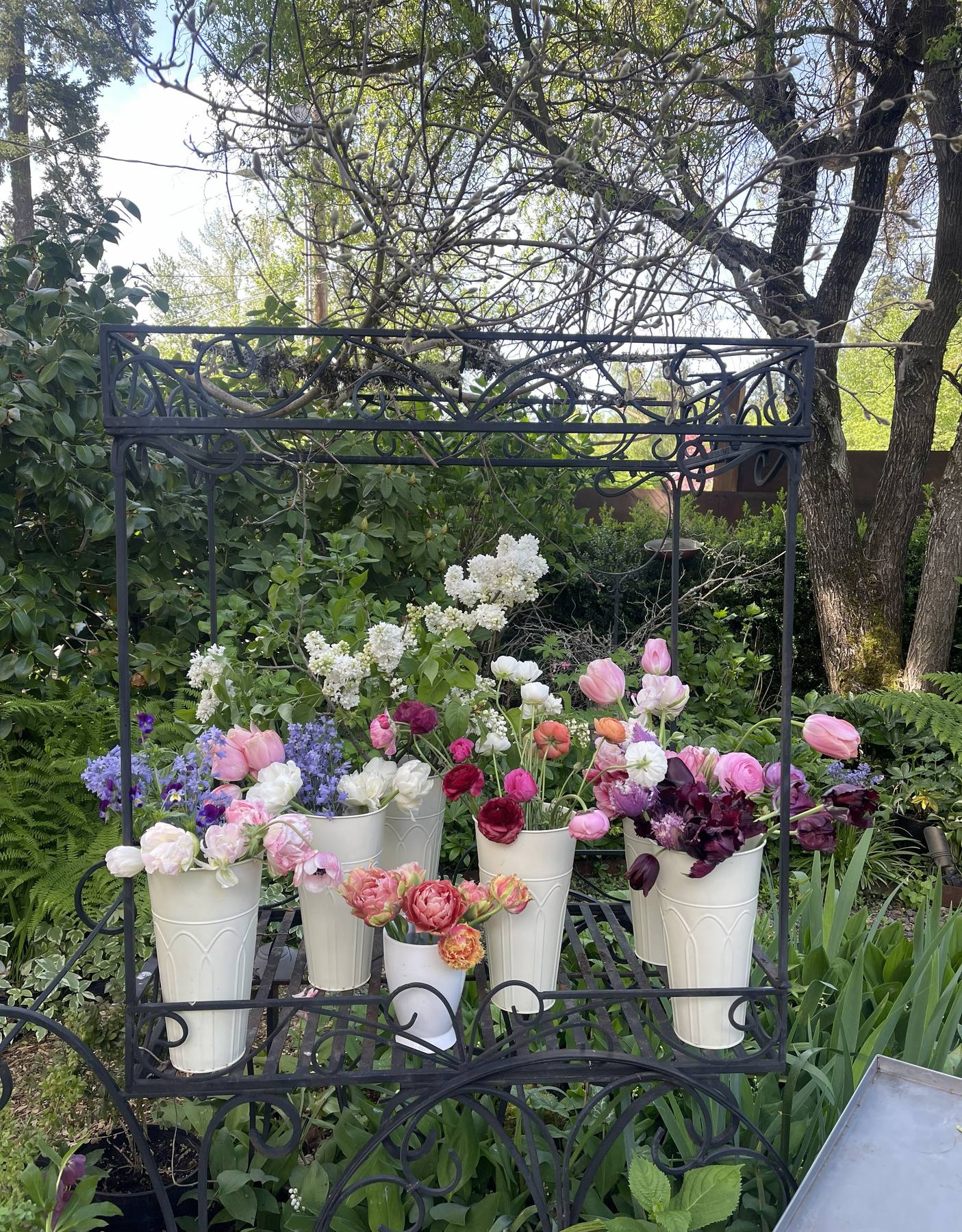Buckets of colorful flowers ready for a bouquet bar
