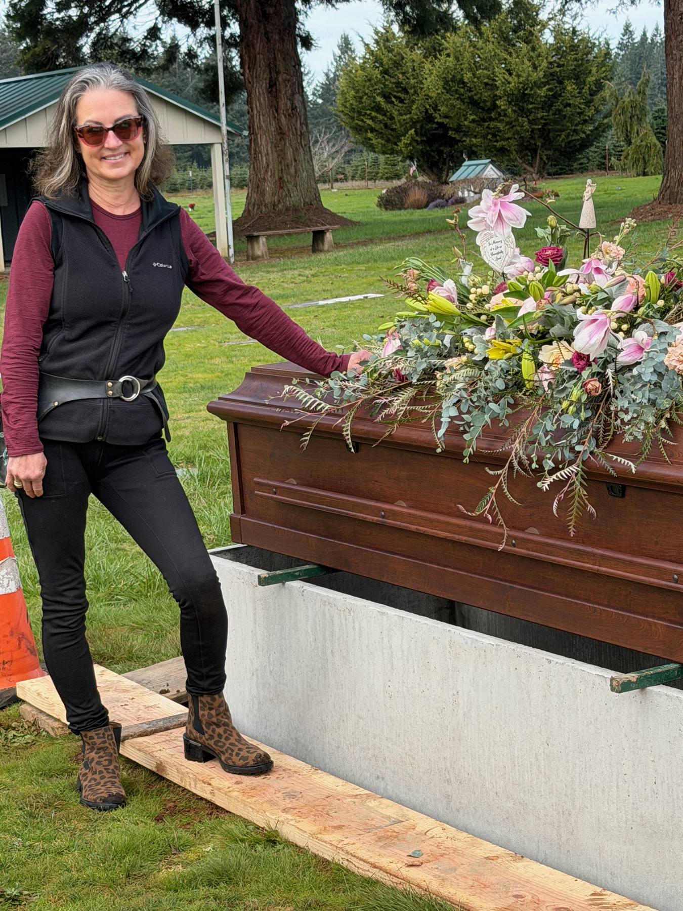 Sonia beside a casket flower arrangement