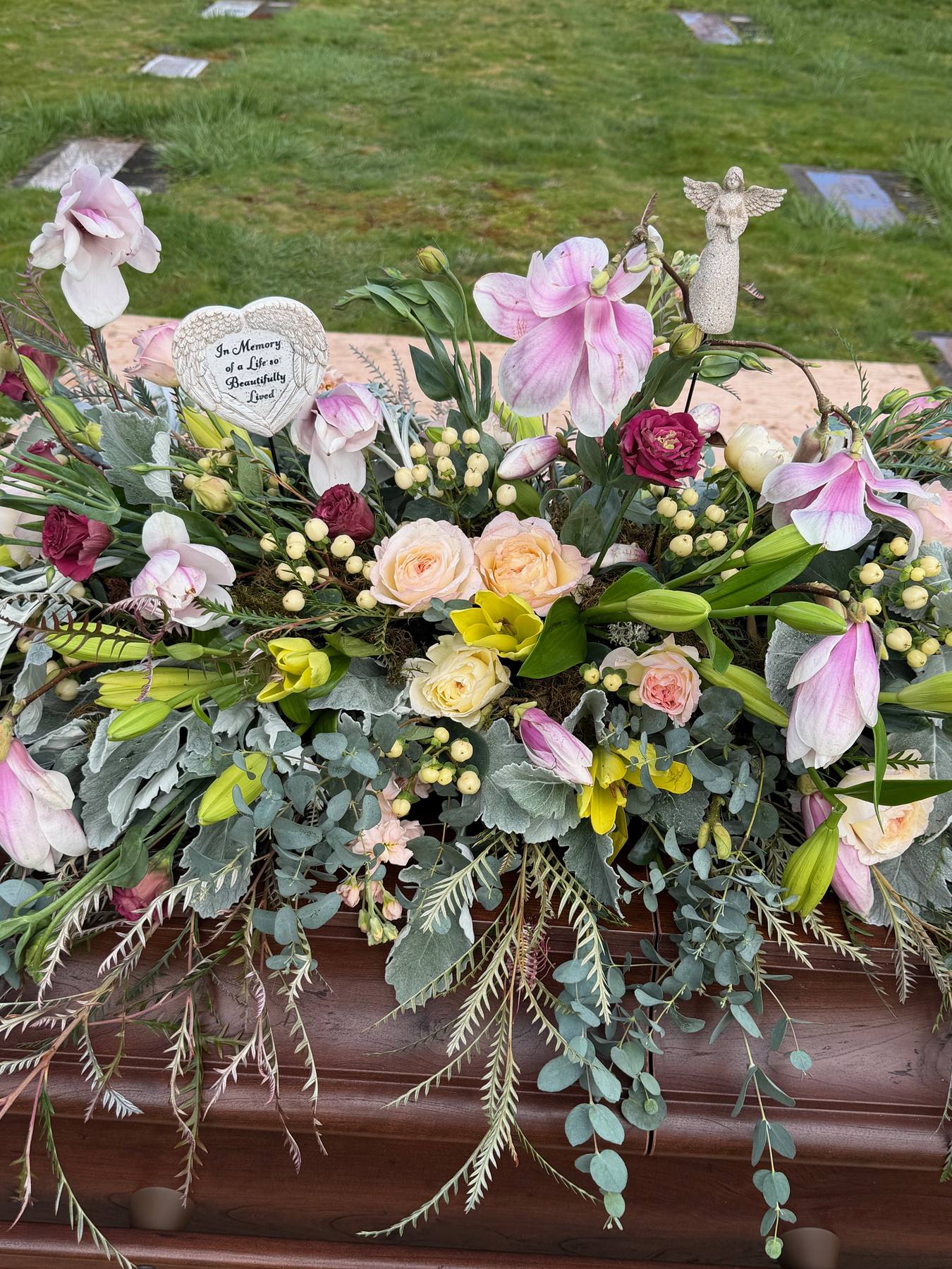 Detailed pastel casket flower arrangement