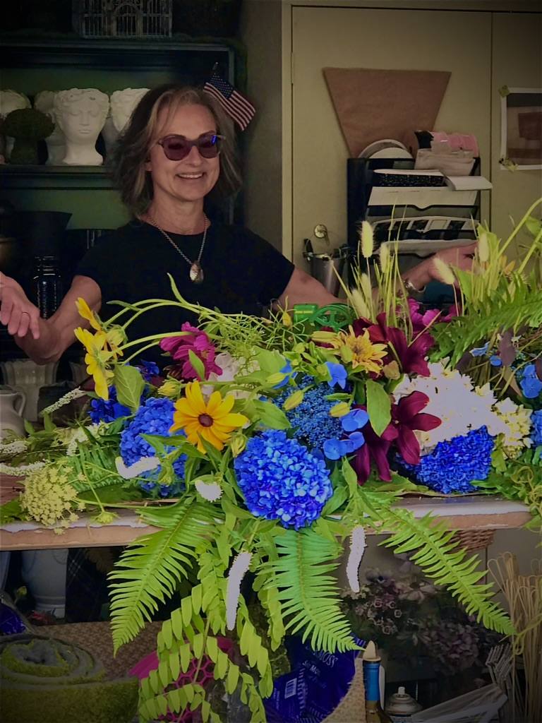 Sonia behind a table of flowers